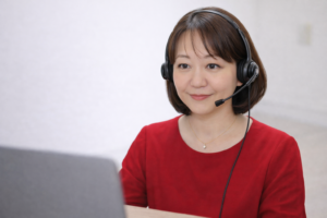 ヘッドセットをつけてノートパソコンでオンライン無料相談を行う長尾円の写真